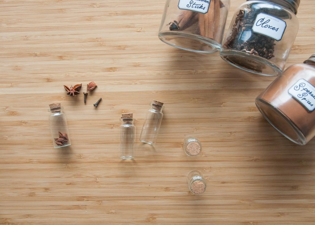 How to Make Apothecary Spice Jar Necklaces for Fall. An array of jars and spices on a table.